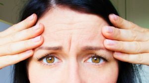 a thirty-year-old woman with wrinkles on her forehead | Common Physical Changes That Come With Aging (And How To Fight Them) | physical changes | physical changes of aging | Featured