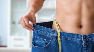 Man in oversized pants in weight loss concept | Feature | Lose Weight Naturally With This Peptide (GLP-1 Benefits)